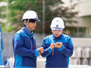 現場で作業内容を確認する社員2人