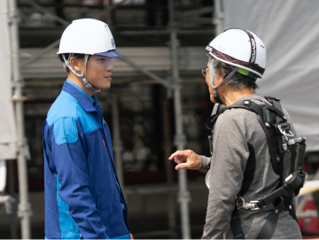 現場で職人さんと打ち合わせる社員