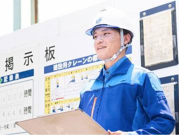 朝礼で職人さんに予定を説明する社員